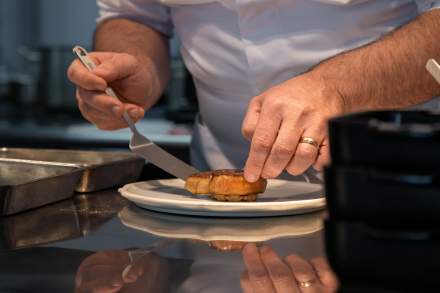 Dressage à la pince — Coulisses du Bistrot 270<br />
Mains du chef posant une garniture à la pince sur un plat en cours de dressage au Bistrot 270