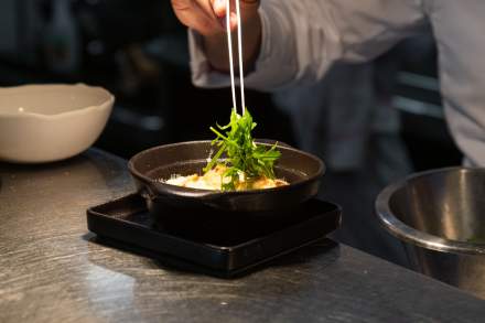 Chef versant un filet de sauce sur un plat en cours de dressage au pass du Bistrot 270